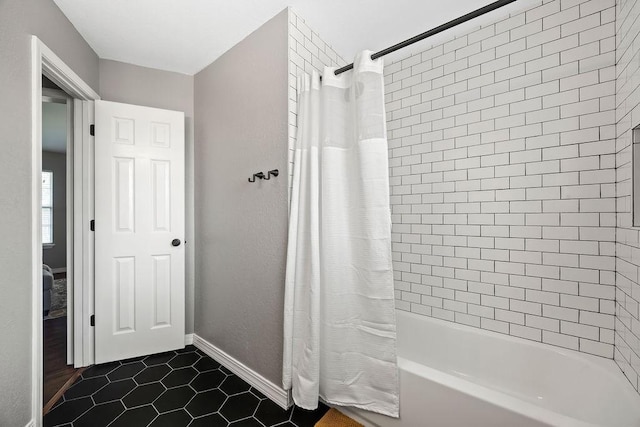 bathroom with baseboards, shower / bath combo, and tile patterned flooring