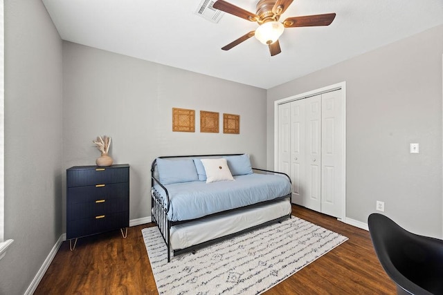bedroom with baseboards, wood finished floors, visible vents, and a closet