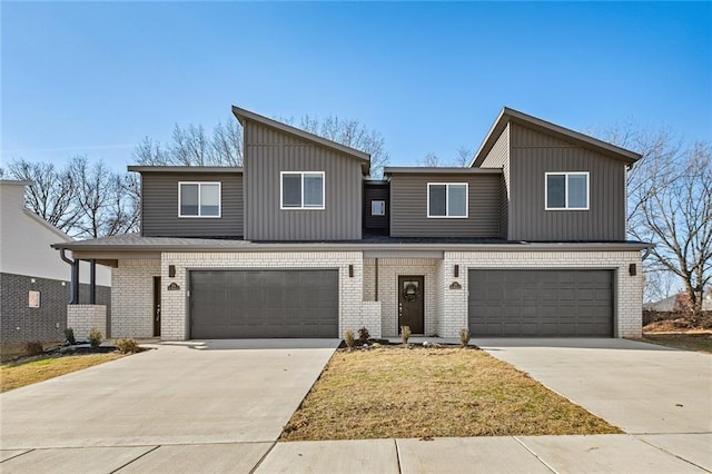 view of property featuring brick siding, driveway, and a garage