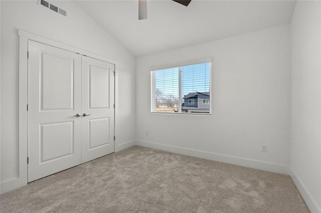 unfurnished bedroom with baseboards, carpet, vaulted ceiling, and visible vents
