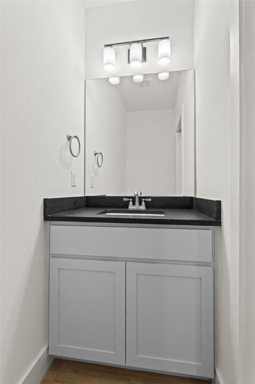 bathroom with vanity, baseboards, and wood finished floors