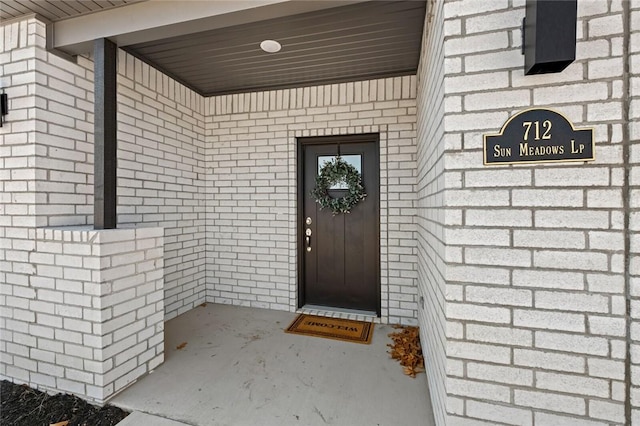 doorway to property featuring brick siding