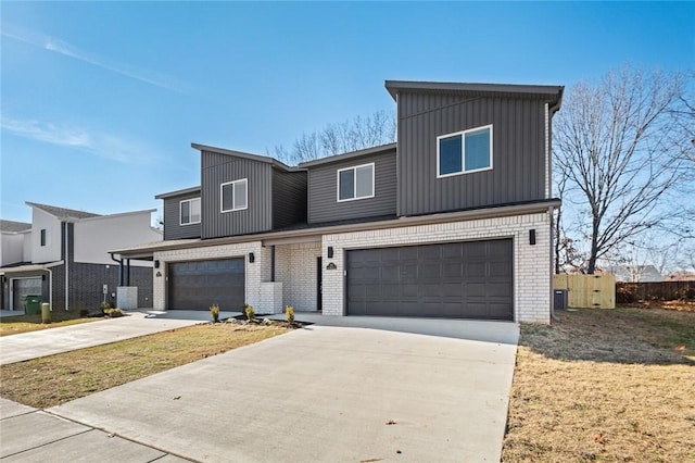 view of front of home with concrete driveway, brick siding, fence, and a garage