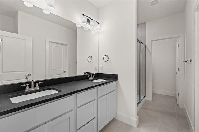 bathroom with a sink, a shower stall, and visible vents