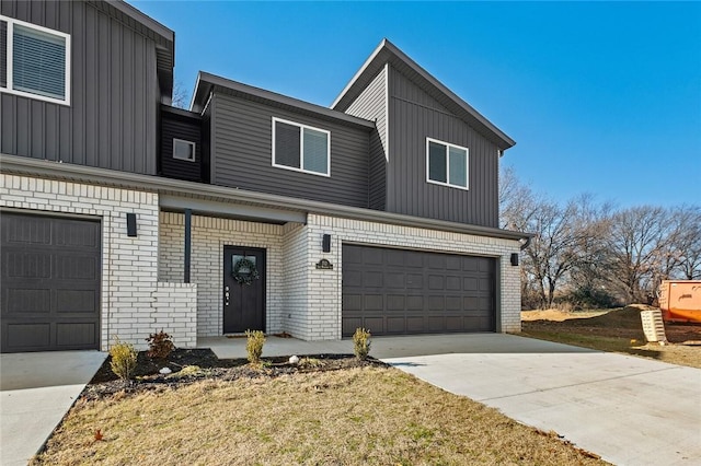 view of front facade featuring board and batten siding, an attached garage, concrete driveway, and brick siding