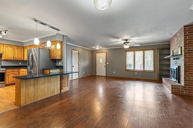 5 Sorbie Dr, Bella Vista, AR 72715 - kitchen with appliances with stainless steel finishes, a ceiling fan, dark countertops, a peninsula, and hardwood / wood-style floors