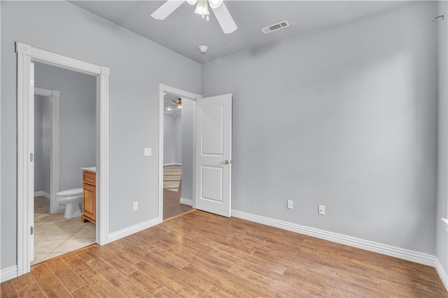 unfurnished bedroom featuring visible vents, connected bathroom, light wood finished floors, and baseboards
