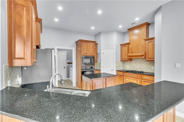kitchen with a sink, a center island, a peninsula, visible vents, and black appliances