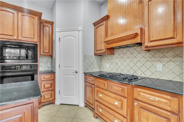 kitchen with premium range hood, dark stone countertops, light tile patterned floors, backsplash, and black appliances
