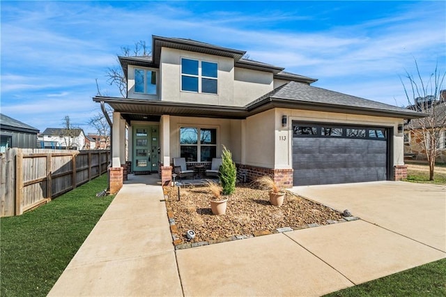 113 SE F St, Bentonville, AR 72712 - prairie-style house featuring covered porch, driveway, fence, an attached garage, and stucco siding