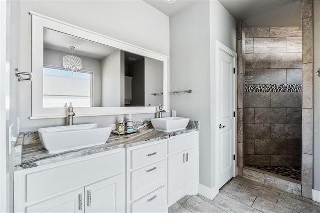 113 SE F St, Bentonville, AR 72712 - full bathroom featuring double vanity, baseboards, a tile shower, and a sink