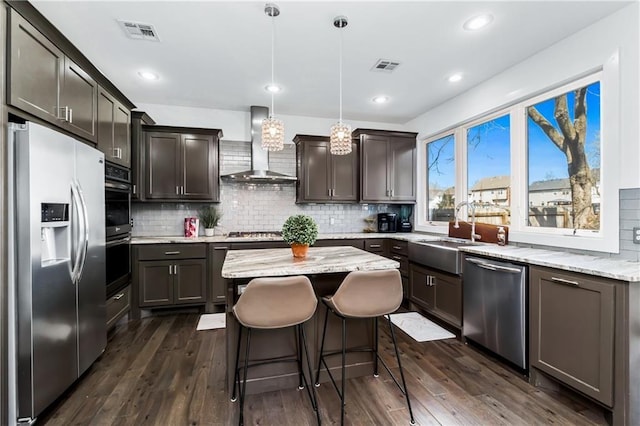 113 SE F St, Bentonville, AR 72712 - kitchen featuring wall chimney range hood, a sink, stainless steel appliances, backsplash, and visible vents
