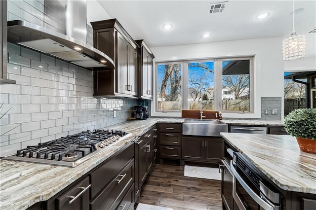 113 SE F St, Bentonville, AR 72712 - kitchen with wall chimney range hood, visible vents, appliances with stainless steel finishes, a sink, and light stone counters
