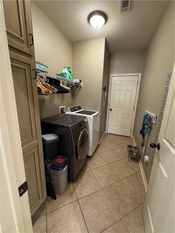 clothes washing area featuring laundry area, independent washer and dryer, visible vents, baseboards, and light tile patterned flooring