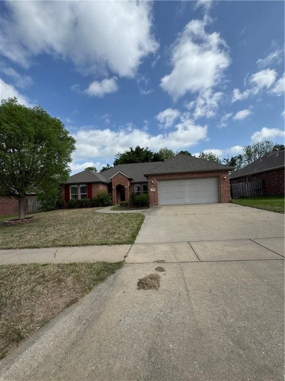 single story home with brick siding, fence, driveway, and a garage