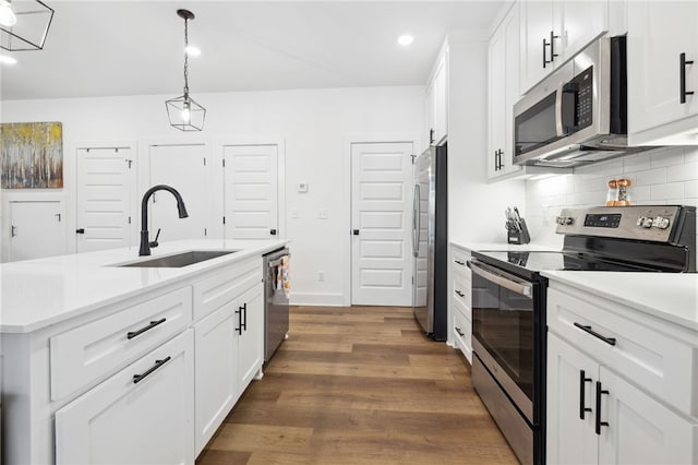 kitchen with decorative backsplash, recessed lighting, light countertops, a sink, and appliances with stainless steel finishes