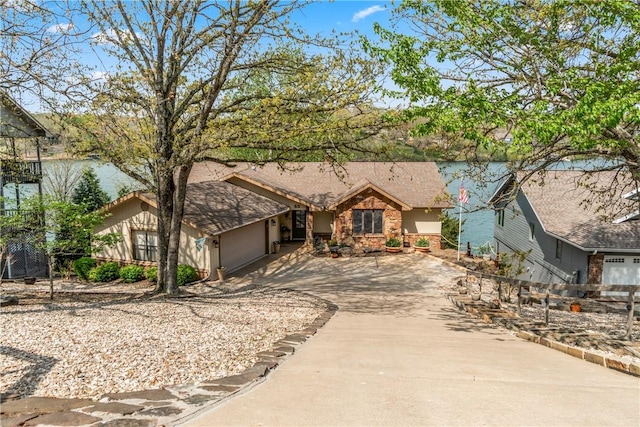 ranch-style house with concrete driveway, an attached garage, fence, and stone siding