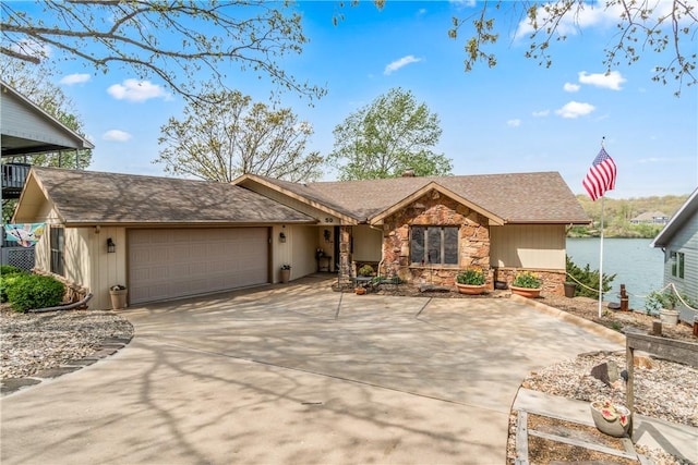 ranch-style home featuring a chimney, roof with shingles, concrete driveway, an attached garage, and stone siding