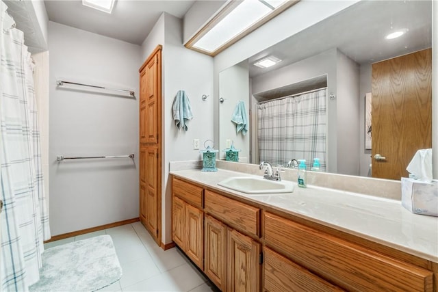 bathroom featuring baseboards, a shower with shower curtain, tile patterned flooring, and vanity