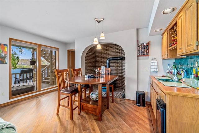 dining room with indoor wet bar, plenty of natural light, and light wood-type flooring