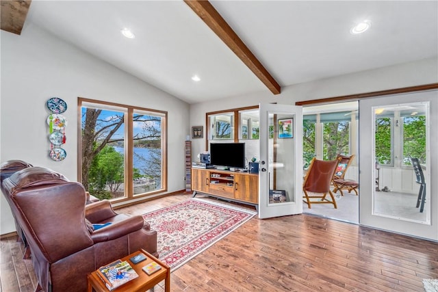 living room with plenty of natural light, lofted ceiling with beams, light wood finished floors, and recessed lighting