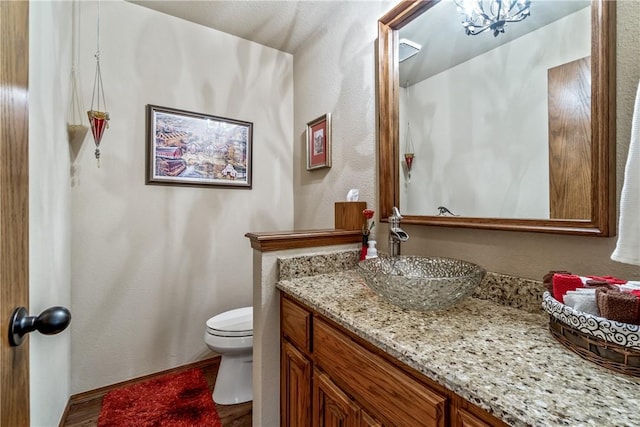 bathroom featuring baseboards, toilet, and vanity
