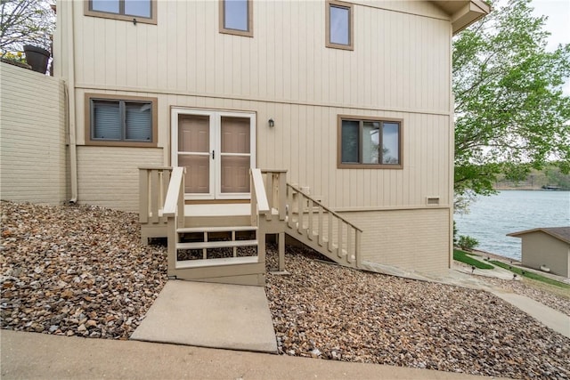 doorway to property featuring brick siding and a water view