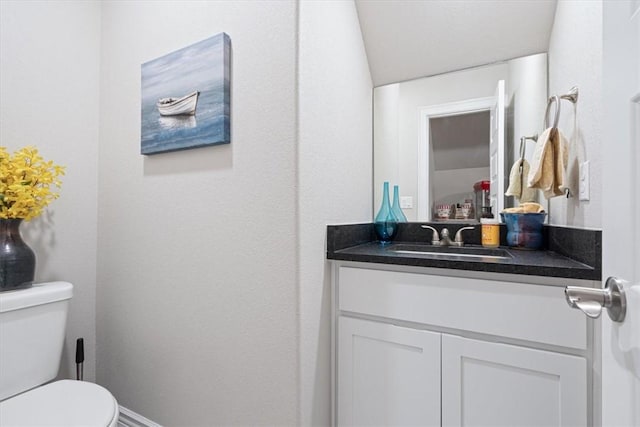 half bathroom featuring vanity and toilet