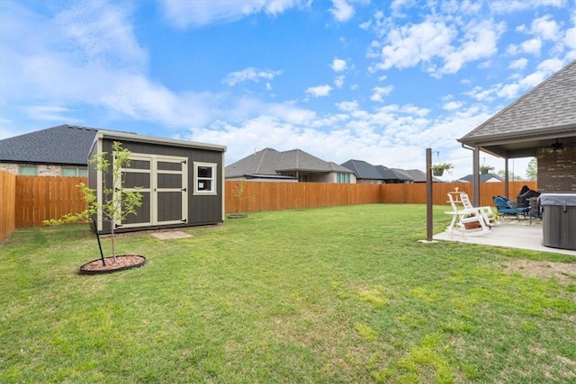 view of yard featuring a fenced backyard, a storage unit, a ceiling fan, a patio area, and an outbuilding