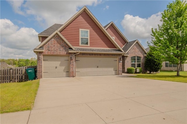 craftsman-style house featuring fence, a front yard, driveway, and brick siding