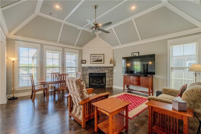 living room featuring ceiling fan, a stone fireplace, baseboards, dark wood-type flooring, and vaulted ceiling