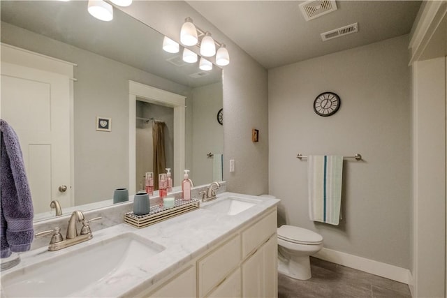 full bathroom with toilet, visible vents, a sink, and wood finished floors
