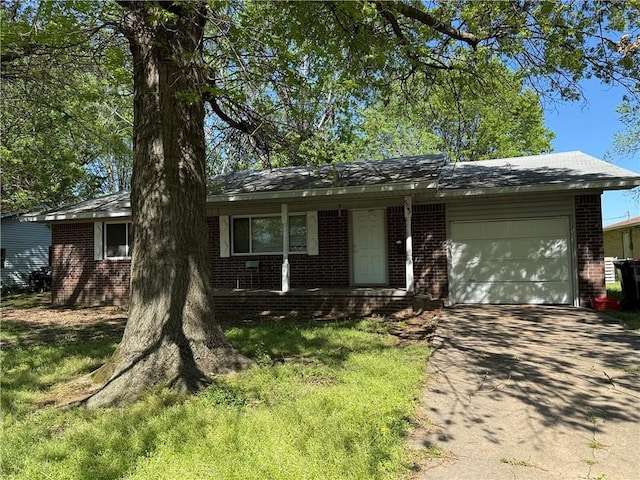 ranch-style house with covered porch, brick siding, an attached garage, and driveway