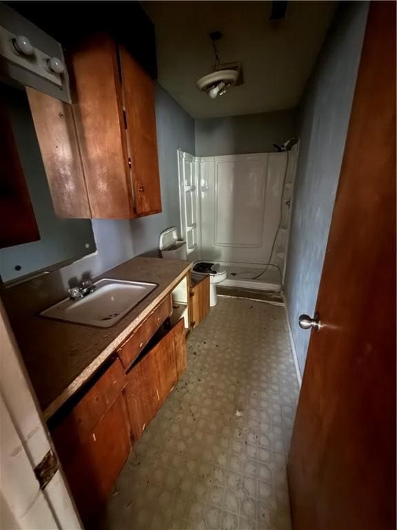 full bathroom with a sink, tile patterned floors, baseboards, and a shower stall