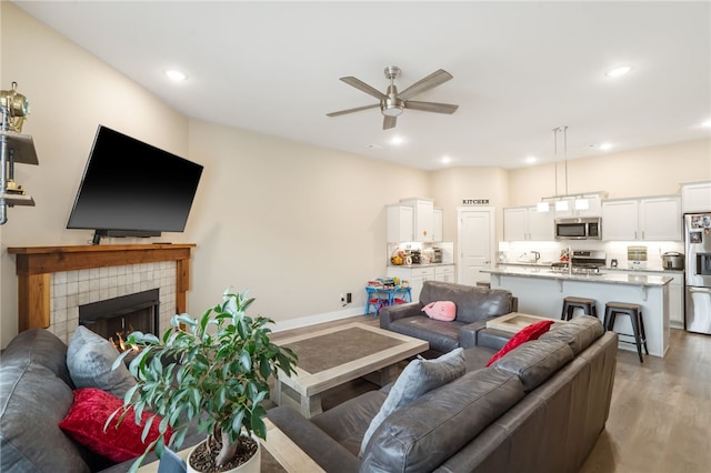 4311 SW Pawhuska St, Bentonville, AR 72713 - living room with a ceiling fan, recessed lighting, light wood-style flooring, and a fireplace