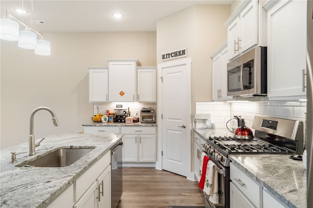 4311 SW Pawhuska St, Bentonville, AR 72713 - kitchen featuring backsplash, light wood-type flooring, a sink, stainless steel appliances, and white cabinetry
