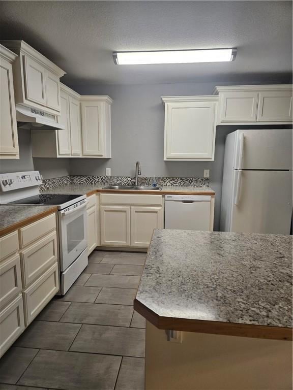 kitchen with white cabinets, a sink, white appliances, wood tiled floor, and under cabinet range hood