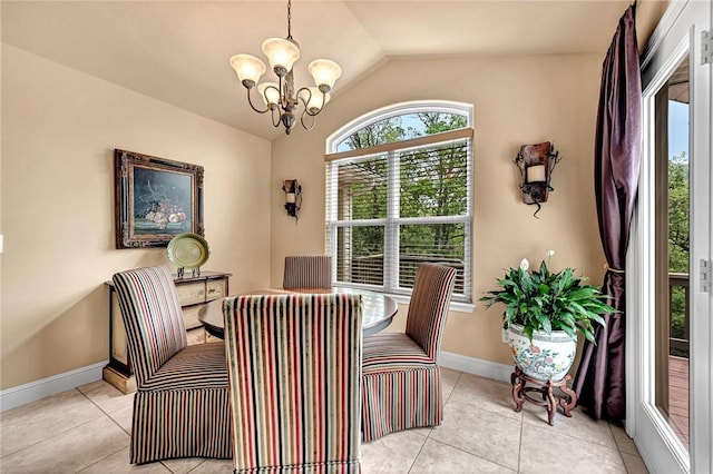 dining space with baseboards, light tile patterned floors, lofted ceiling, and a chandelier