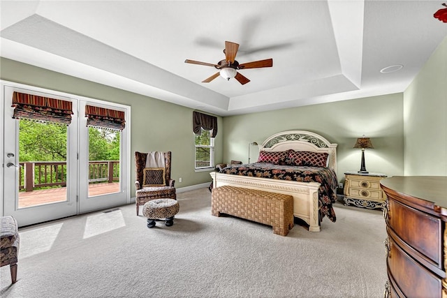 bedroom with baseboards, ceiling fan, access to outside, a tray ceiling, and carpet