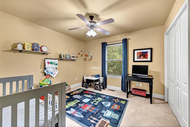 bedroom with a closet, baseboards, a ceiling fan, and carpet flooring