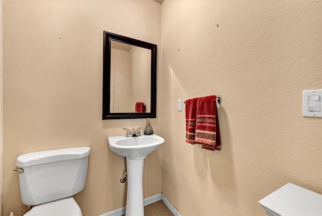bathroom with toilet and baseboards