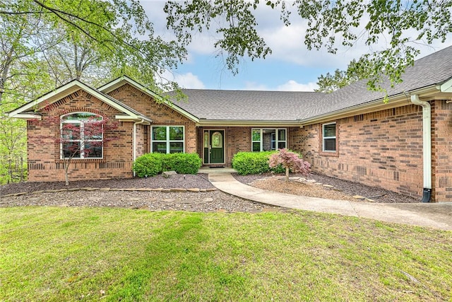 ranch-style house featuring brick siding, roof with shingles, and a front yard
