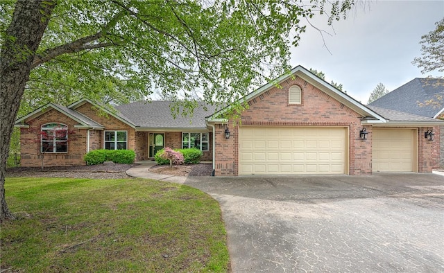 ranch-style home with a garage, a front yard, roof with shingles, brick siding, and concrete driveway