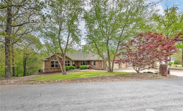 single story home featuring an attached garage, concrete driveway, and brick siding