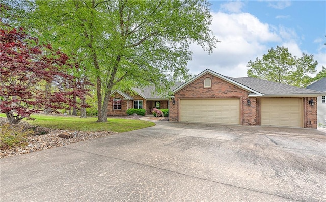 ranch-style house with a garage, a front yard, driveway, and brick siding