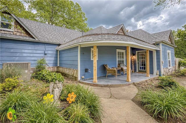 302 4th Ave, Gravette, AR 72736 - rear view of house featuring central AC unit, roof with shingles, and a porch