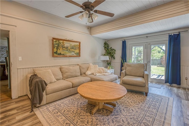 302 4th Ave, Gravette, AR 72736 - living room featuring wood finished floors, wainscoting, a ceiling fan, and wooden walls