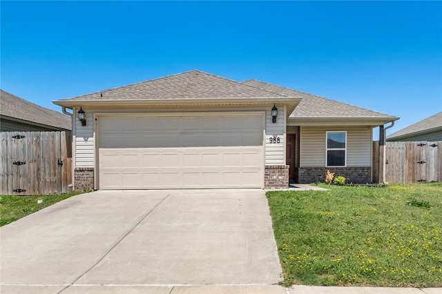 988 E Bunting St, Fayetteville, AR 72701 - view of front facade with brick siding, an attached garage, driveway, and fence