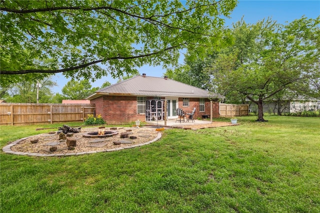 rear view of property featuring brick siding, an outdoor fire pit, a patio area, and a yard