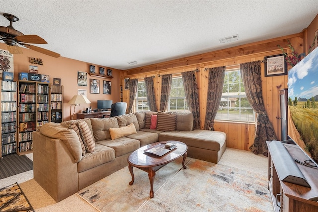 living room featuring a textured ceiling, ceiling fan, light carpet, and a healthy amount of sunlight